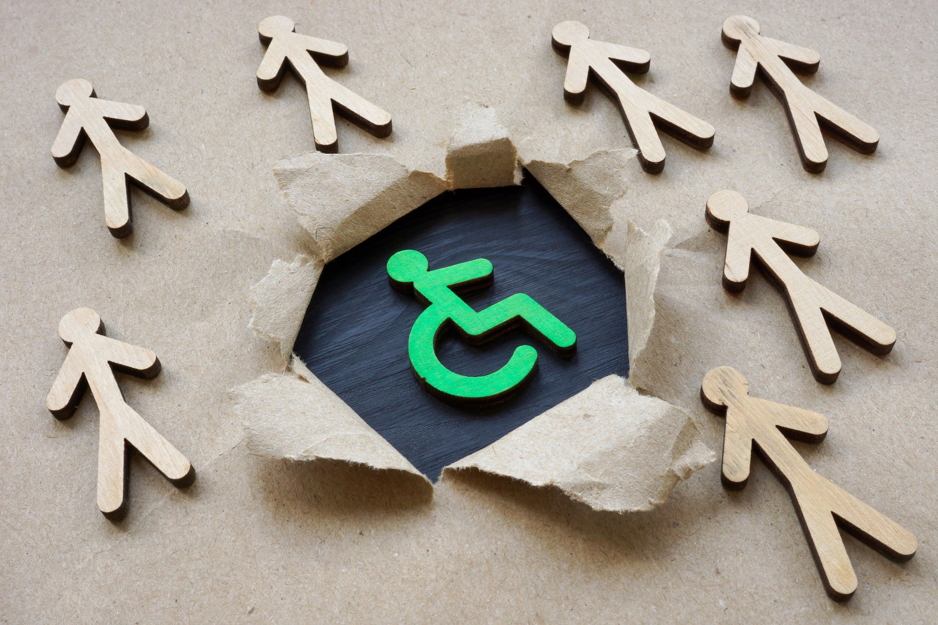 Social inclusion concept. Disabled person sign and figurines.