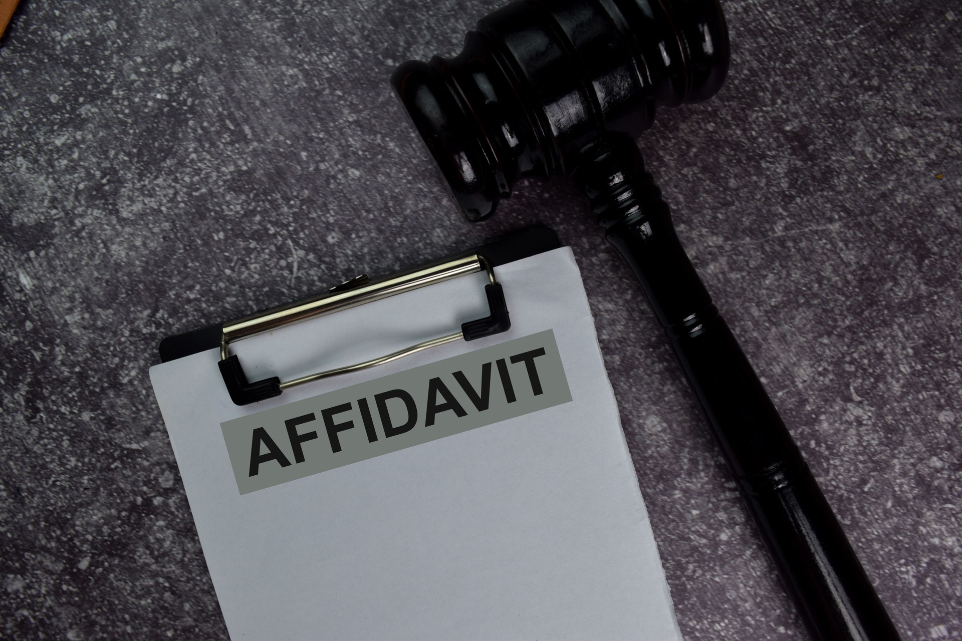 Affidavit text write on a paperwork and gavel isolated on office desk.