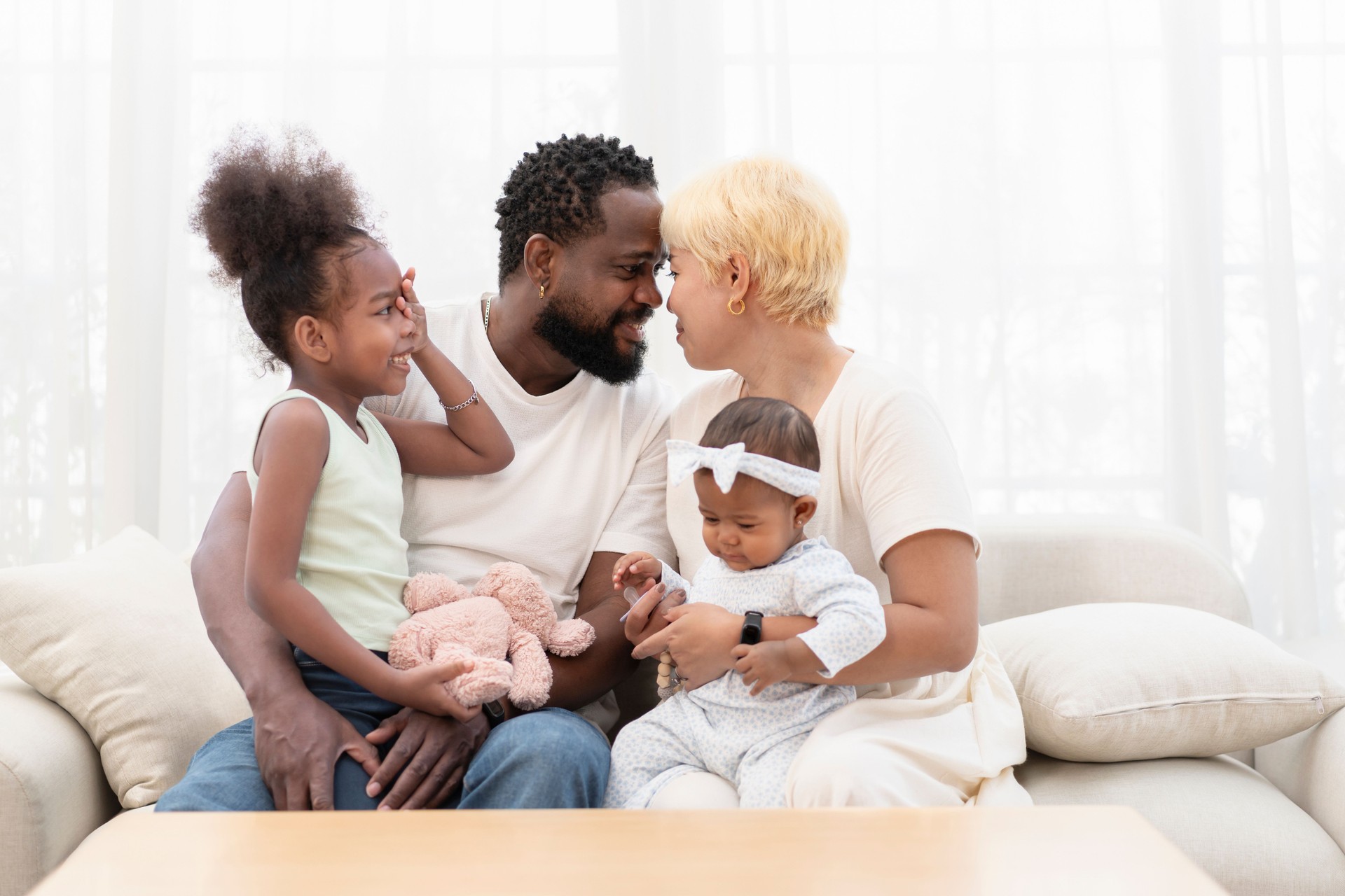 portrait romantic couple with two kids,bonding interracial family spend free time together in cozy room at home